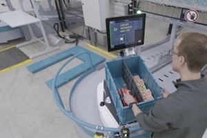 AMR AS/RS机器人沿着工作站斜坡向上移动，并向操作员展示其内容。操作员的显示屏显示了产品的位置，SKU描述和选择的数量，以及放置它的位置，以获得更高的准确性和吞吐量性能