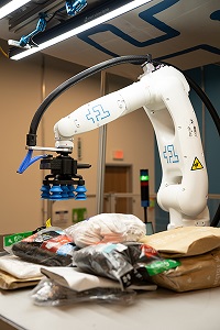 Plus One Robotics的解决方案采用人工智能软件，带有末端机器人抓手，提供拾取和放置包裹金宝搏188官网app网址所需的感知和操作
