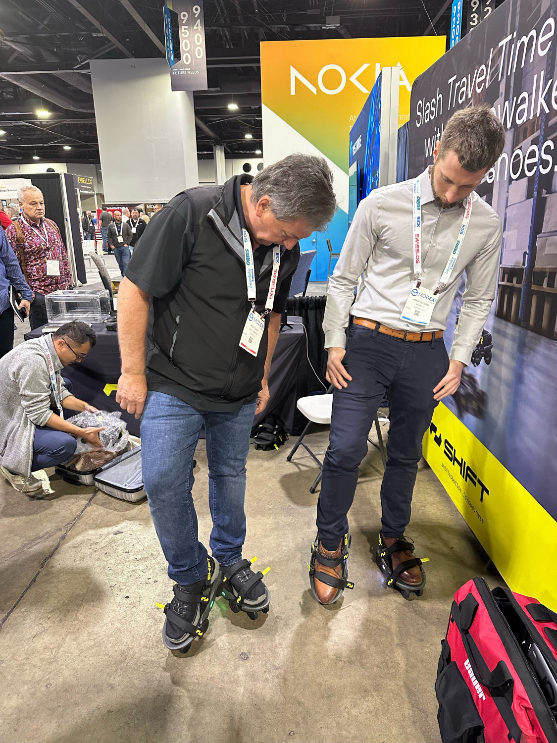 From left, Rob Vickery, global head of business development at Shift Robotics (Booth A9422), demonstrates how to operate their Moonwalkers. Powered by artificial intelligence (AI), Moonwalkers can be strapped onto shoes to give warehouse workers a gentle motorized push. Shift Robotics says the product can double warehouse productivity, thanks to fewer steps taken.