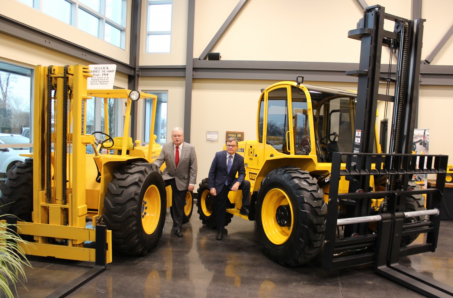 Howard (at left) and David Sellick with a couple of the company’s forklifts.