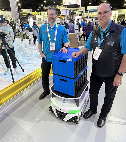 Locus Robotics的市场开发副总裁杰森·沃克和Locus Robotics的首席执行官里克·福克带着一个Locus Vector机器人，它可以处理高达600磅的有效载荷。