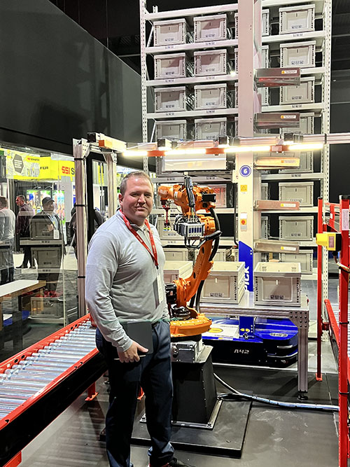 克里斯托弗•VanDeWiele肉类的产品经理,points out how HAI’s ACR robots bring goods to a Mujin robotic piece picking system, as part of MHS’s new goods-to-robot solution.