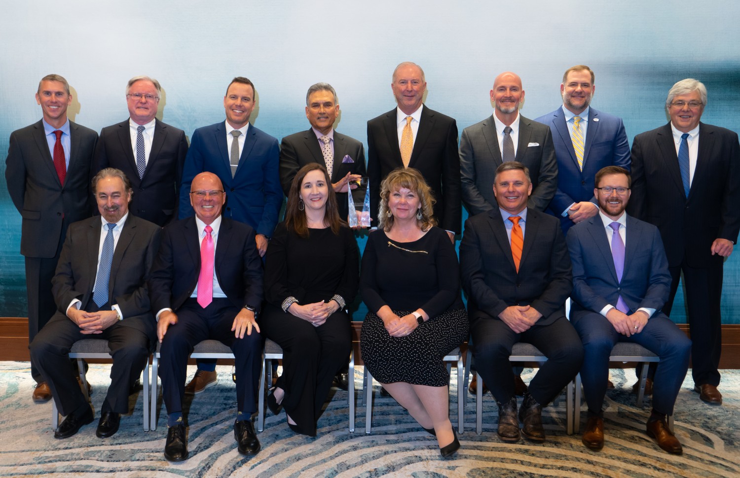 Caption: Toyota Material Handling (TMH) recognizes 15 of the company’s top dealers with the prestigious President’s Award at their annual Dealer Meeting in Columbus, Ind., March 22, 2022. (Front Row Left to Right: Ken Townsend, Toyota Lift of South Texas; Ron McCluskey, Brodie Toyota-Lift; Anika Conger-Capelle, Conger Toyota-Lift; Joyce Schwob, JIT Toyota-Lift; David Bailey, Southern States Toyotalift; Kyle Hudson, Western Materials Handling & Equipment Ltd.; Back Row Left to Right: Chris Frazee, ProLift Toyota Material Handling; Larry McKevitt, Summit ToyotaLift; Mark Andres, Toyota Material Handling Northern California; Shankar Basu, Toyota Material Handling Solutions; Jim Shoppa, Shoppa’s Material Handling, Ltd.; Jeff Burns, Kenco Toyota-Lift; Michael Turnmyre, VESCO Toyotalift; Scott Plummer, W.D. Matthews Machinery Co.; not Pictured: Brent Bahrns, Bahrns ToyotaLift.